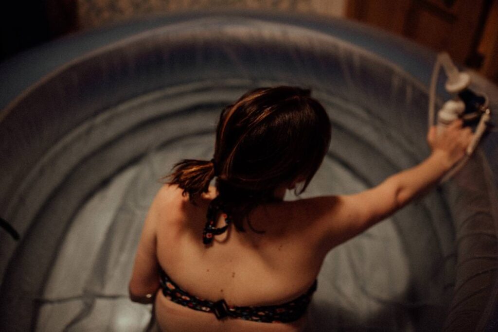 Home water birth with mother breathing through contractions in a birthing pool.