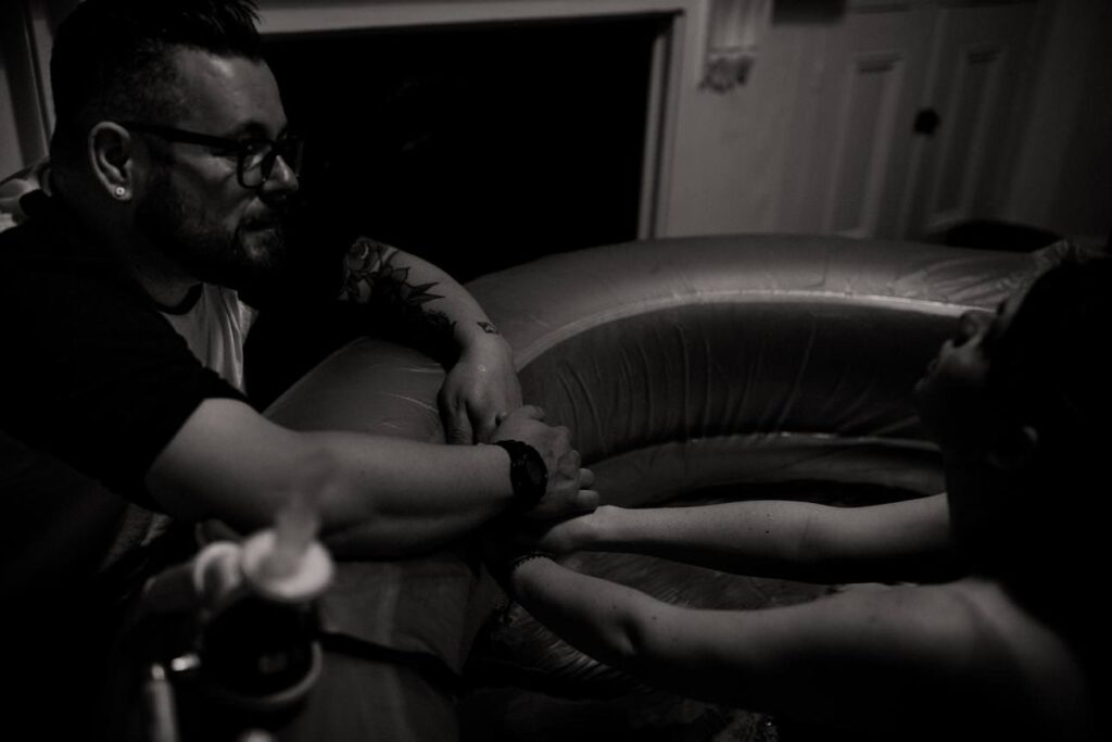 close up of hands holding each other during a home water birth