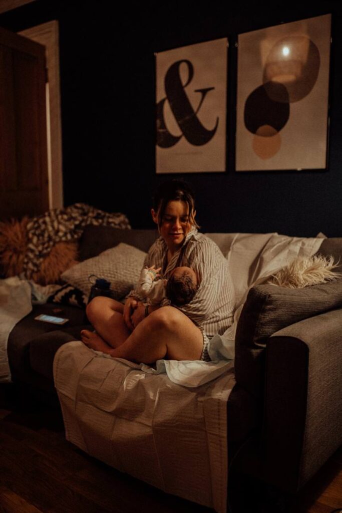 Mother resting after birthing, her baby held close.