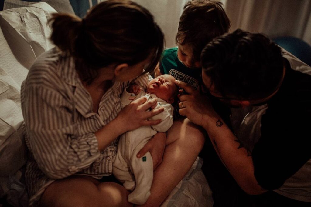 little boy meeting his baby sister for the first time.