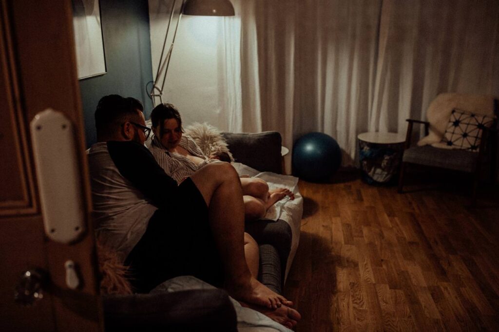 couple soaking in their newborn moments after she's born.