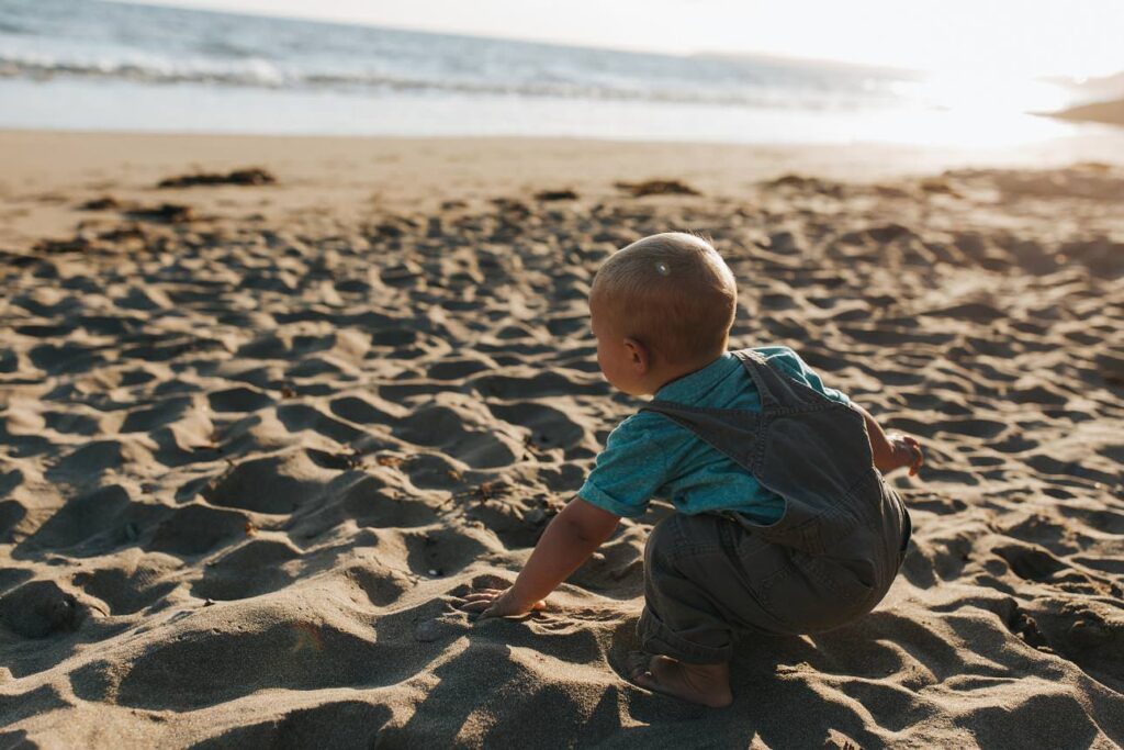 Toddler playing in the sand during a sunset family photography session in Cornwall