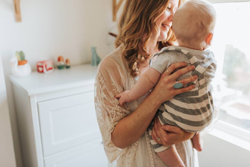 a mother holding her son illuminated by soft window light
