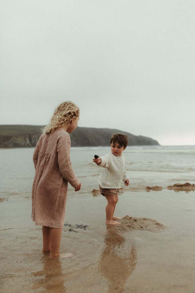 two children play in the sea during lifestyle family photography session