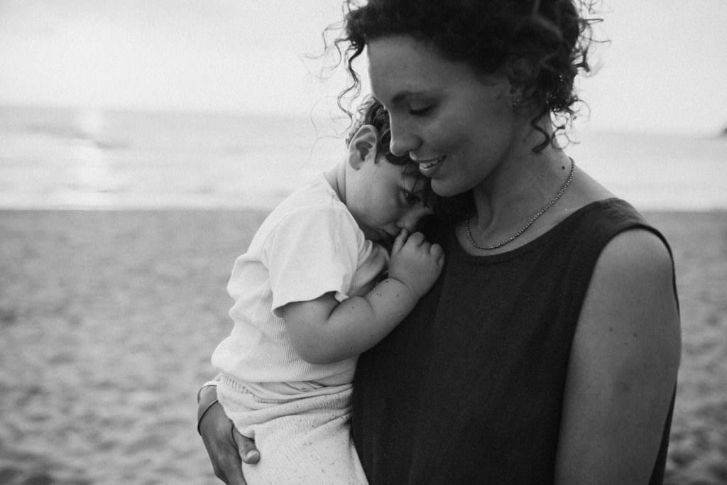 lifestyle family photography toddler snuggles into mothers neck black and white image