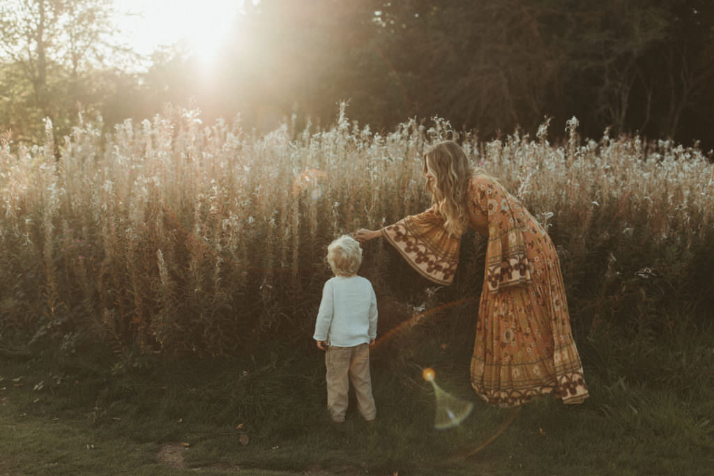 family photographer devon shoot Mum and son near beautifully lit wild grasses