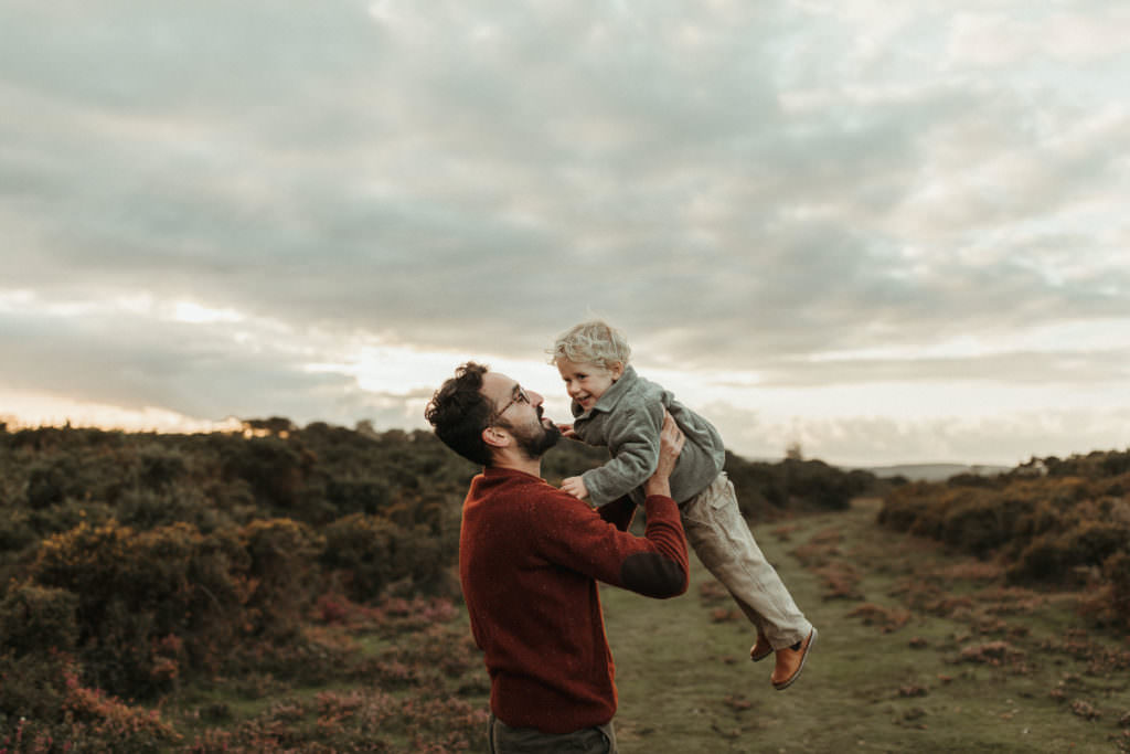 family photographer devon shootDad spins son around both smiling at each other