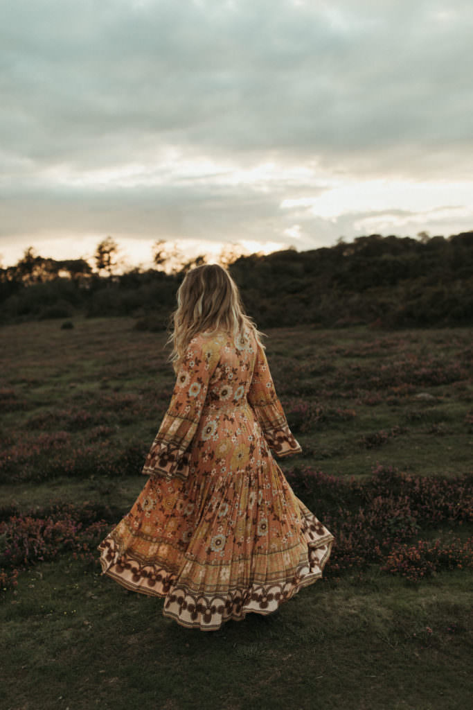 family photographer Woman wears orange dress and twirls in a circle
