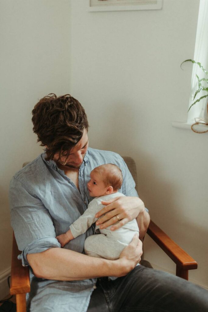 natural newborn portrait of baby sleeping on parent’s chest at home in St Agnes