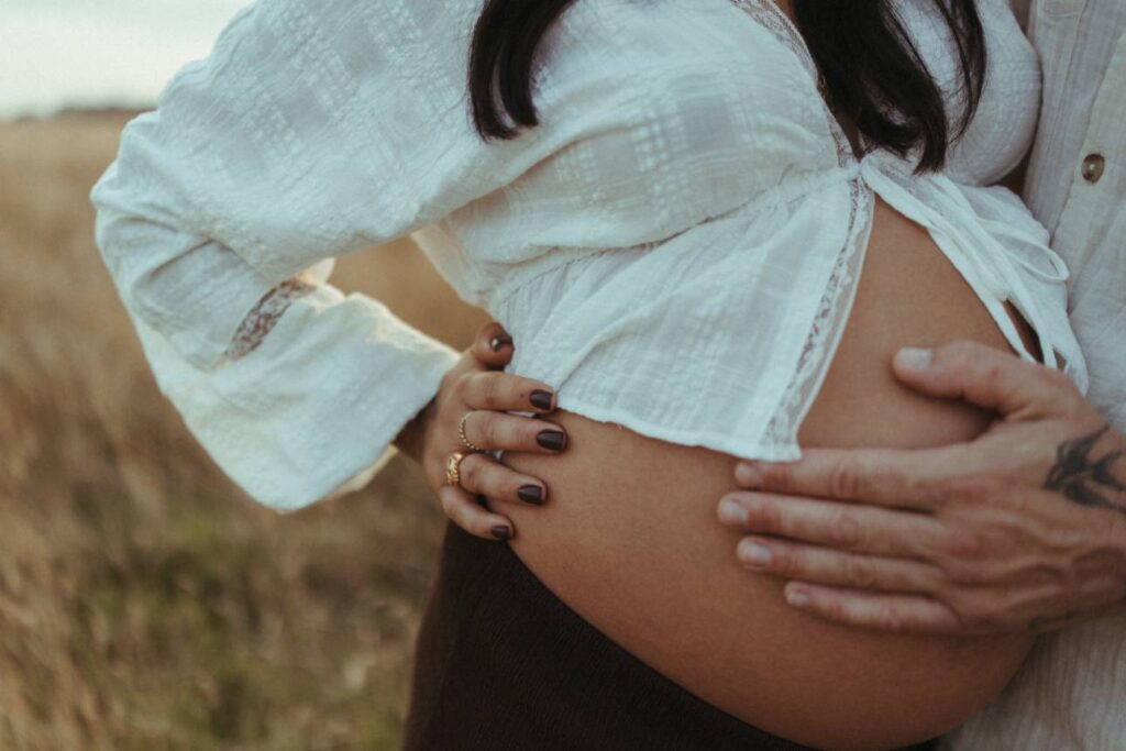 hands on bump during a relaxed outdoor maternity shoot in Cornwall