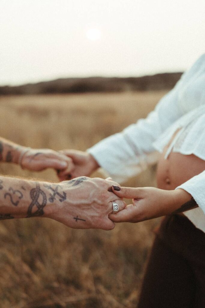 A couple holding hands during their sunset maternity photoshoot