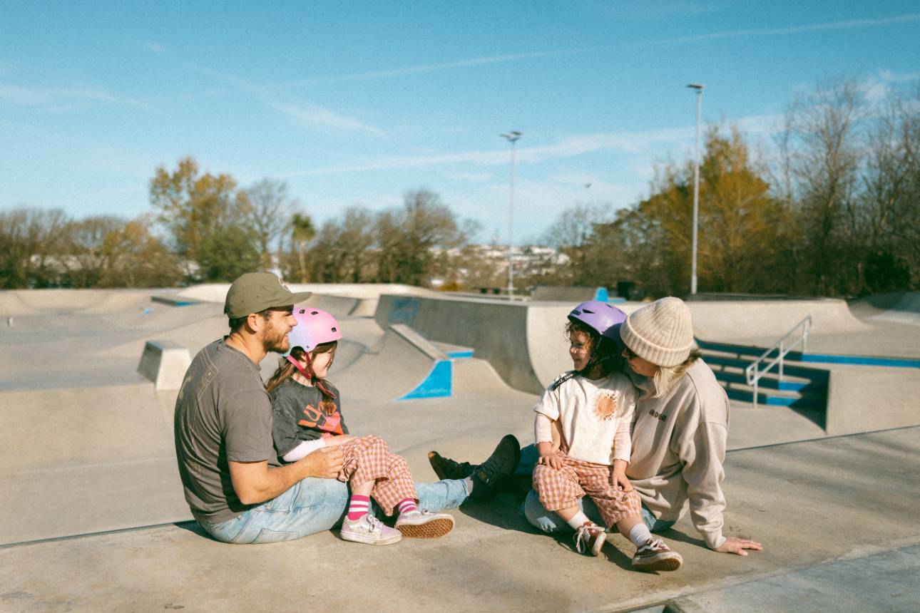 Family sat on skate ramp during their family photography session at a skate park in newquay Cornwall