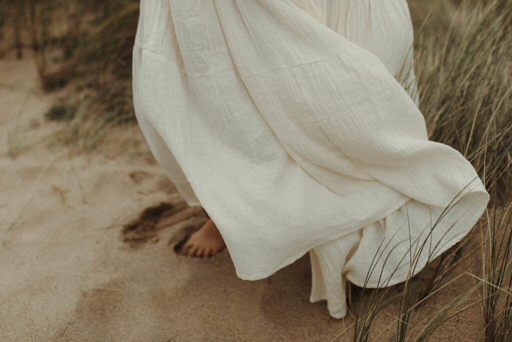 dress blowing in the wind during her maternity photoshoot in Cornwall