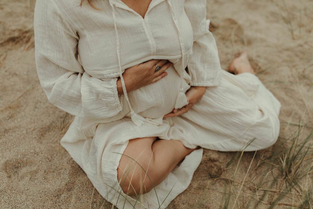 hands holding her bump during a maternity session in Cornwall