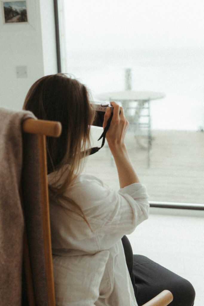 An image of a woman taking photos of the sea