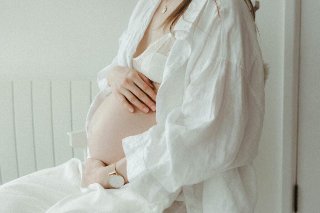 A detail image of a mother holding her baby bump