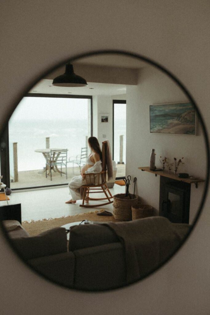 A mirror reflection of a pregnant woman sat in her home in Porthleven