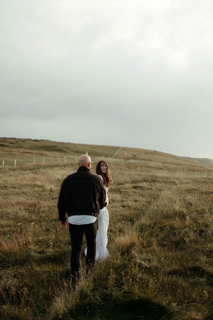 A couple walking the Cornwall coastal path during their maternity photoshoot