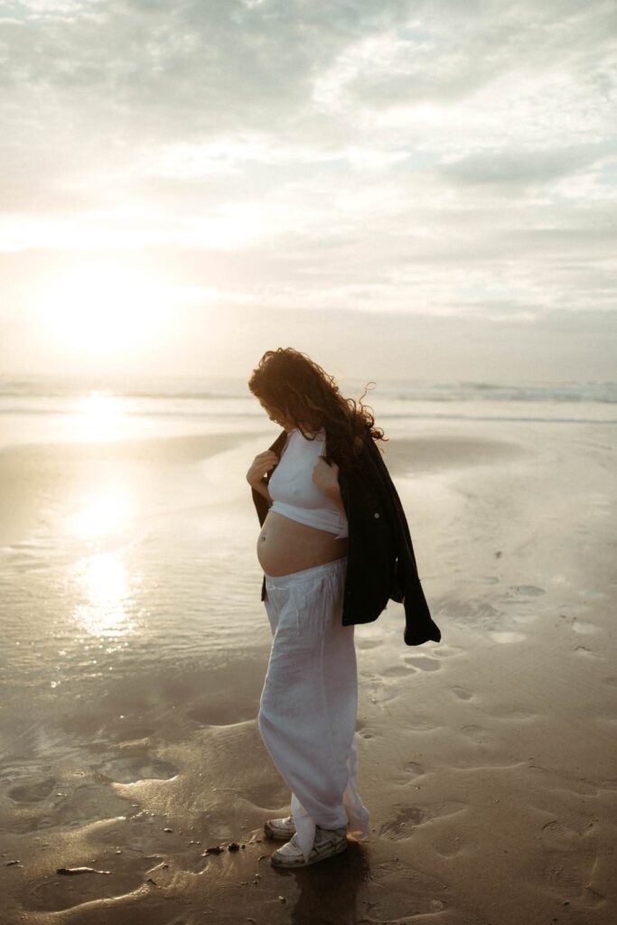 maternity photography session in Cornwall with an expectant mother walking at sunset