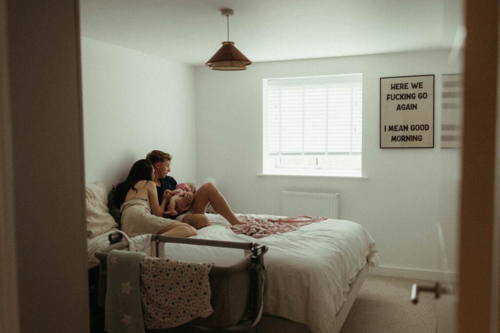 Baby photoshoot at home in Cornwall with soft morning light and family cuddles